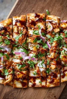 BBQ Chicken Flatbread topped with fresh ingredients and drizzled with sauce