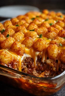 Chili Cheese Tater Tot Casserole topped with melted cheese and chili