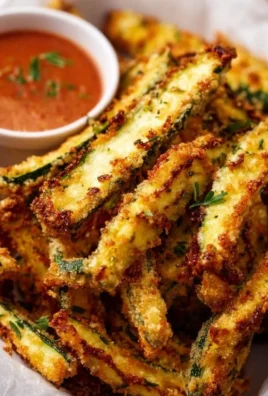 Crispy baked keto zucchini fries served on a plate with dipping sauce