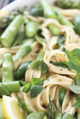 A vibrant plate of spring pasta with peas and asparagus, garnished with fresh herbs.