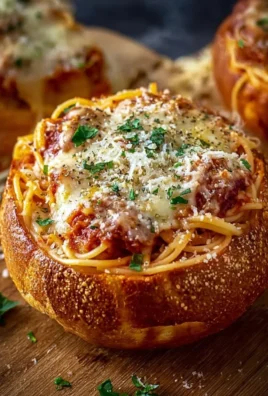 Spaghetti garlic bread bowls filled with pasta and garnished with herbs