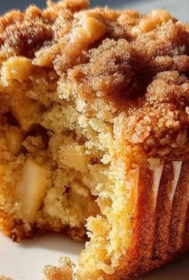 Freshly baked apple cinnamon muffins with streusel topping on a wooden table