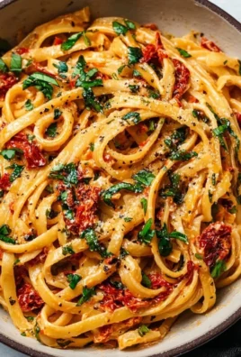 Vegan creamy sun dried tomato pasta served in a bowl with fresh basil.