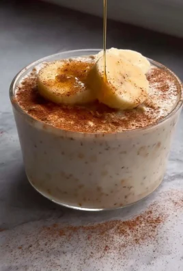 A bowl of Banana Cinnamon Overnight Oats topped with banana slices and cinnamon.