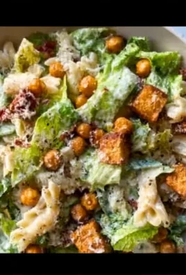 Caesar Pasta Salad with Chickpea Croutons in a bowl garnished with fresh herbs