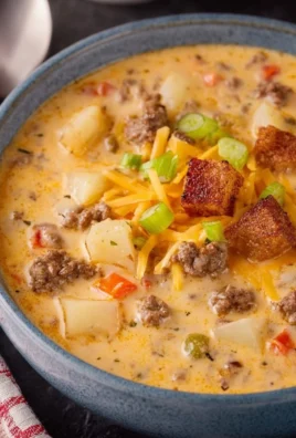 Delicious cheeseburger soup served in a bowl with fresh herbs and toppings