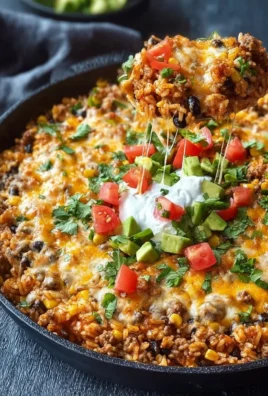 Cheesy Taco Rice Skillet garnished with fresh ingredients in a frying pan