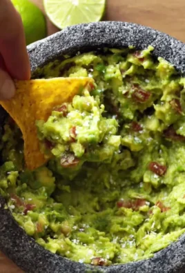 Delicious guacamole served in a bowl with tortilla chips on the side