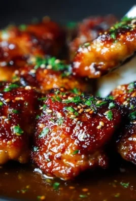 Savory honey garlic chicken thighs garnished with herbs on a plate