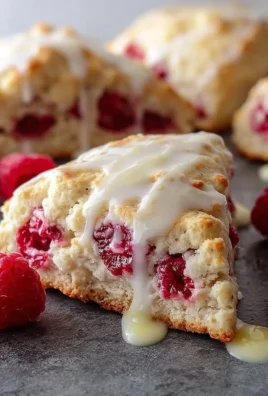 Freshly baked lemon raspberry scones on a cooling rack.
