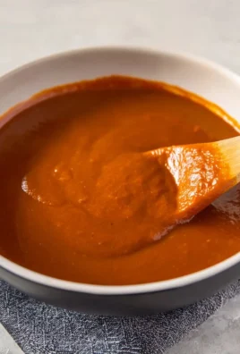 Homemade red enchilada sauce in a bowl, perfect for adding authentic flavor.