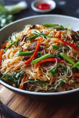 Colorful rice noodle stir-fry with vegetables in a frying pan
