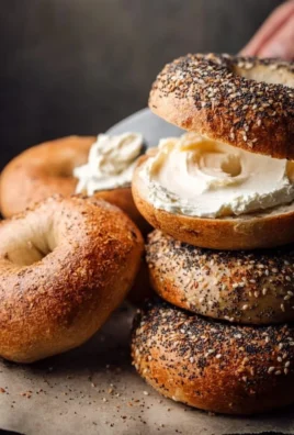 Homemade sourdough discard bagels resting on a wooden kitchen board.