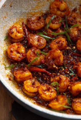 Plate of spicy shrimp garnished with herbs and spices