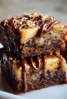 Delicious banana bread brownies on a plate, topped with chocolate drizzle