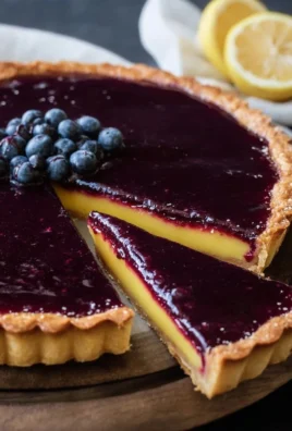 Blueberry lemon curd tart topped with fresh blueberries and lemon zest