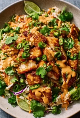 Chicken Crispy Rice Salad topped with Peanut Dressing in a colorful bowl