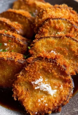 Crispy eggplant katsu served with dipping sauce on a plate