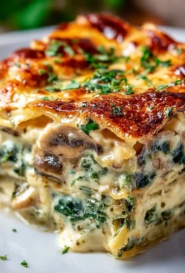 Easy creamy spinach mushroom lasagna on a plate with fresh herbs