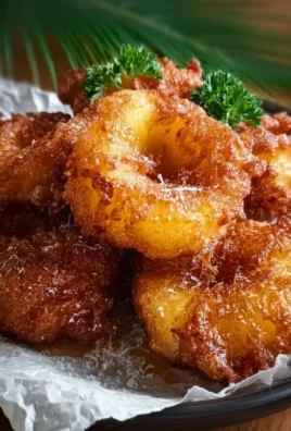 Delicious pineapple fritters served on a plate with tropical fruit garnish
