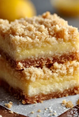 Delicious lemon crumb bars with a buttery crumb topping on a white plate