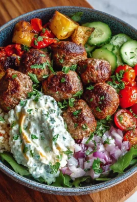 Delicious Mediterranean meatballs bowl garnished with fresh herbs and vegetables.