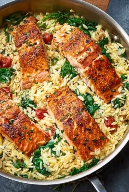 Skillet salmon served with lemon orzo in a vibrant dish.