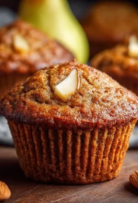 Freshly baked spiced pear muffins with a golden crust and warm spices.