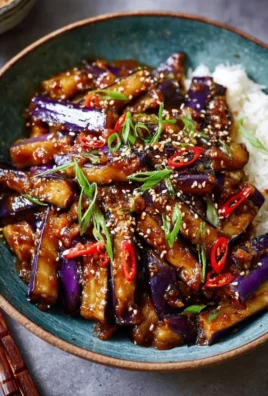 Spicy eggplant stir fry with colorful vegetables in a skillet