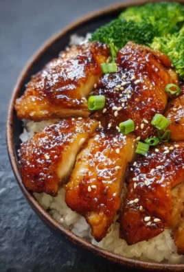 Delicious sticky chicken rice bowls garnished with vegetables and sauce