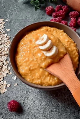 Bowl of creamy sweet potato oats porridge topped with nuts and fruits