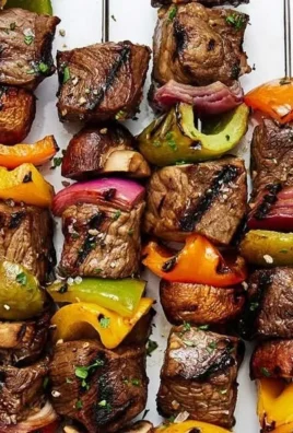 Juicy beef shish kabob skewers with colorful vegetables on the grill