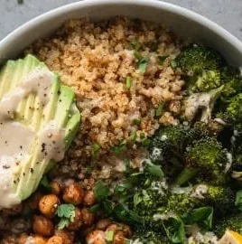Crispy quinoa chickpea bowl topped with roasted broccoli and lemon tahini sauce