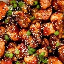 Delicious plate of easy chicken teriyaki garnished with sesame seeds and green onions.