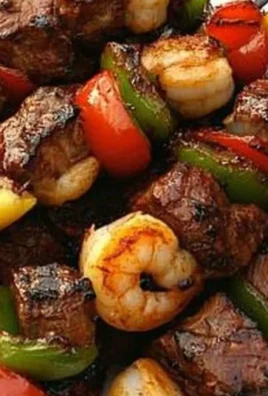 Grilled steak and shrimp kabobs on skewers ready for serving