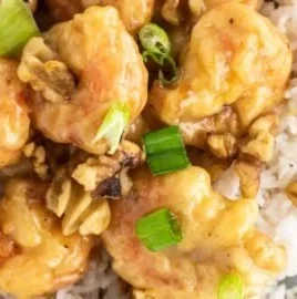 Delicious honey walnut shrimp dish garnished with walnuts and green onions.