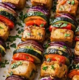 Vegan grilled lemon-herb tofu skewers served with corn and tomato salad