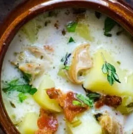 Bowl of authentic New England clam chowder with fresh clams and herbs