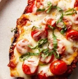 Crispy baked eggplant parmesan with melted cheese and fresh herbs
