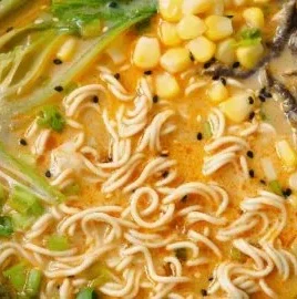 Bowl of easy vegan one-pot spicy miso ramen with fresh vegetables and herbs
