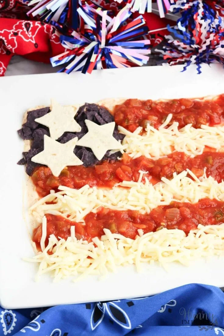 Colorful flag taco dip garnished with fresh toppings