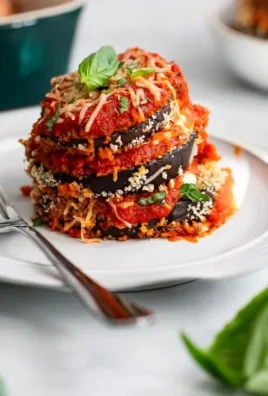 Healthy eggplant parmesan dish topped with fresh basil and melted cheese