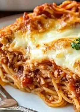 Delicious homemade spaghetti pie topped with cheese and herbs